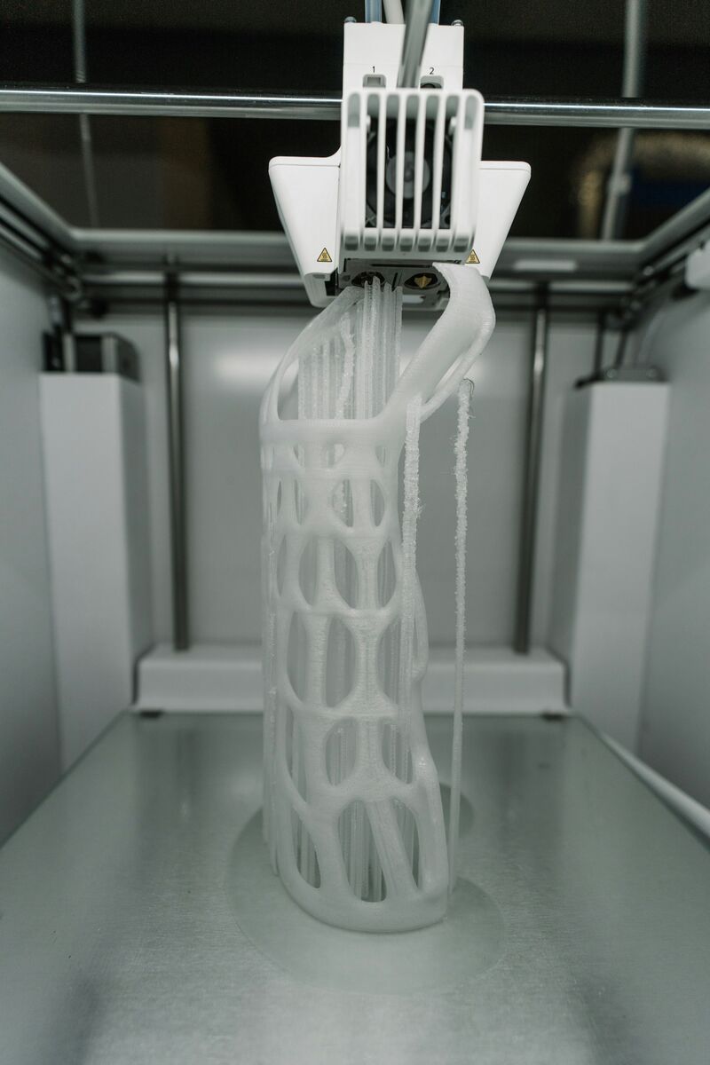 Bílý mřížkový prototyp vznikající v 3D tiskárně